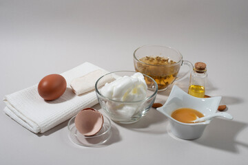 Egg White Face Mask ingredients. Whipped egg white, almond oil, honey, chamomile tea. Homemade cosmetic.