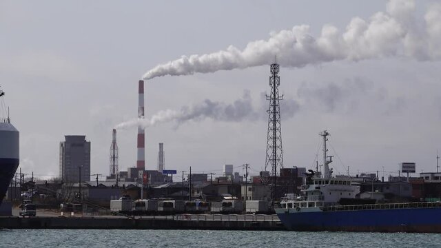 工場の煙突から出る煙  温室効果ガス削減のコンセプトイメージ