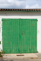 green wooden garage door with peeling paint
