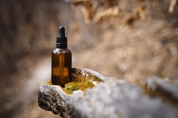 Serum for face in the forest. Skincare routine step for healthy skin. Essence for Healthy Skin. Filler for wrinkles. Hyaluronic acid, skin hydration, bottle drops. Beauty and cosmetic concept. 