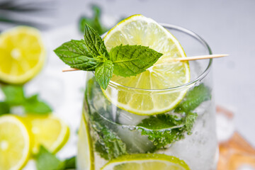 Refreshing mojito with lime, mint and ice in a glass close up. Cold summer cocktail