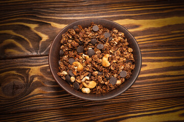Chocolate granola cereal with nuts in a bowl.