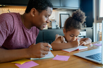 Naklejka premium A father helping his daughter with homeschool.