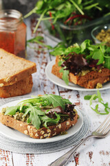 Homemade sandwiches with pesto, green salad and poached eggs	