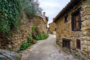 Fototapeta na wymiar Narrow alley in an old medieval town made of stone in the Sierra de Madrid. Horcajuelo.