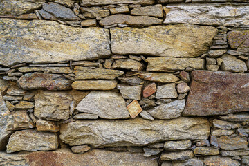 Rustic looking stone wall background used for old house construction.