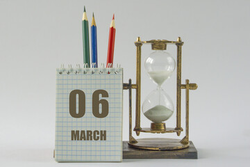 Day of month.Calendar,sand in vintage hourglass, colored pencils, notepad,procrastination and planning concept, time management