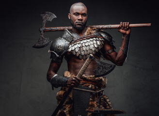 Black skinned antique soldier with dual axes looking at camera