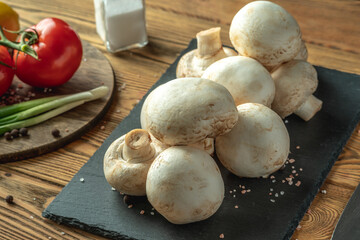 Mushrooms, vegetables and spices on a wooden table. Concept of ingredients for cooking a delicious food
