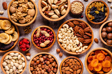 Various Nuts and dried fruits in wooden bowls.
