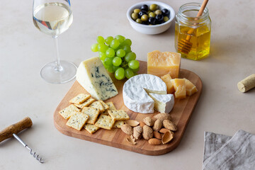 Cheese plate with cracker, almonds and grapes. Wine appetizer. Wine snack.