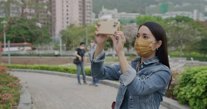 Woman wear face mask and use of smart phone to take photo