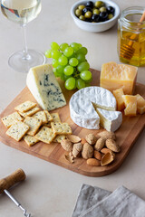 Cheese plate with cracker, almonds and grapes. Wine appetizer. Wine snack.