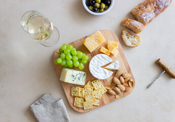 Cheese plate with cracker, almonds and grapes. Wine appetizer. Wine snack.