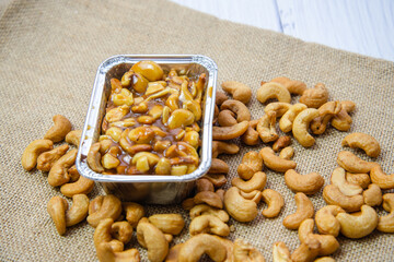 Homemade Toffy cake or chocolate cake with cashew nut in the disk on the sack background. Delicious dessert or snack.
