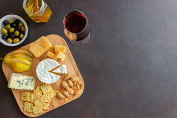 Cheese plate with cracker, almonds and grapes. Wine appetizer. Wine snack.