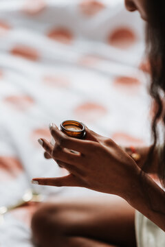 Young African Female Holding A Jar Of Lip Balm