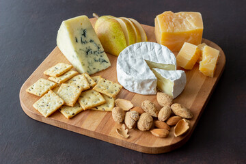 Cheese plate with cracker, almonds and grapes. Wine appetizer. Wine snack.