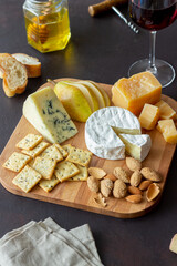 Cheese plate with cracker, almonds and grapes. Wine appetizer. Wine snack.