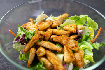 Dietary salad with chicken and lettuce in a glass dish.