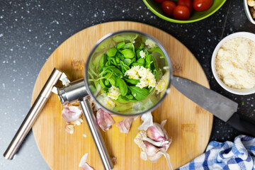 Prepare basil pesto. Adding ingredients to the blender. Basil leaves, garlic, and nuts.