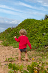 child playing on the beach vegetation