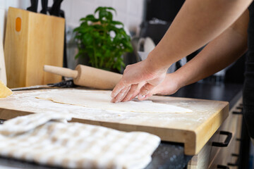 Fototapeta na wymiar A person rolling the dough for homemade lasagne pasta.