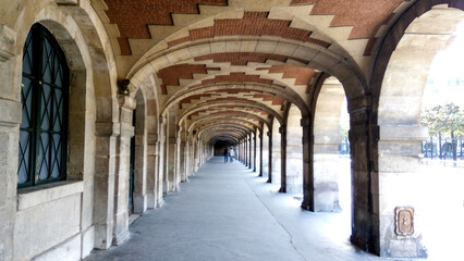 Beautiful archway in the old town country. Young people walking in historic place.