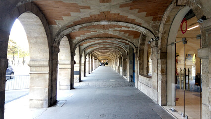 Beautiful archway in the old town country. Young people walking in historic place.