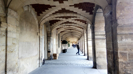 Obraz premium Beautiful archway in the old town country. Young people walking in historic place.
