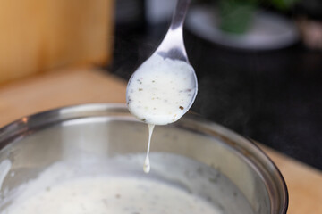 Bechamel sauce dripping from the kitchen spoon