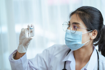 Vaccine and drug for COVID-19, Closeup woman doctor or scientist in laboratory holding a coronavirus vaccine or drug bottle, Vaccination for against prevent infection concept