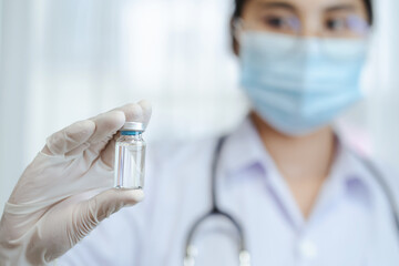 Vaccine and drug for COVID-19, Closeup woman doctor or scientist in laboratory holding a coronavirus vaccine or drug bottle, Vaccination for against prevent infection concept