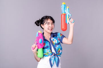 Beautiful Asian women hold plastic water guns at an ancient temple during Songkran, the most beautiful and fun water festival in Thailand