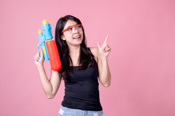 Beautiful Asian women hold plastic water guns at an ancient temple during Songkran, the most beautiful and fun water festival in Thailand