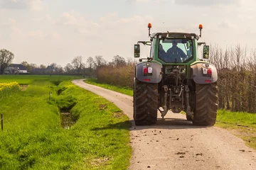 Tuinposter A tractor in the countryside in the spring in the Betuwe. © Jan van der Wolf