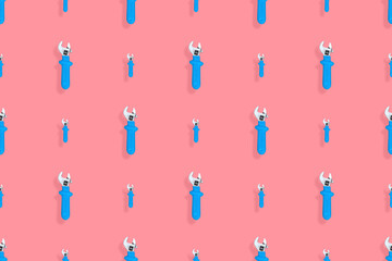 Background from a metal adjustable wrench with a rubber handle. Tools seamless pattern.