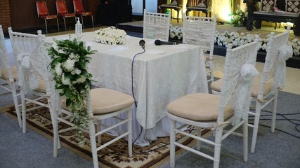 Yogyakarta, Indonesia, March 26, 2021. Some chairs and tables have been decorated in white nuances prepared for a marriage consent procession.