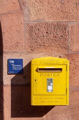 Wissembourg, France. September 13th, 2009. Yellow mailbox on the facade of a building in the historic center of the town.