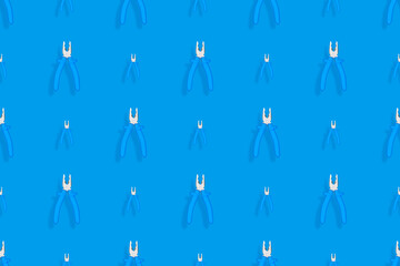 Background of metal pliers with rubber handles. Tools seamless pattern.