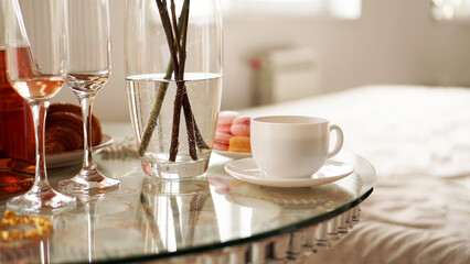 Glass table with a cup of coffee, sweet macaroons.