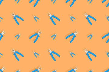 Background of metal pliers with rubber handles. Tools seamless pattern.