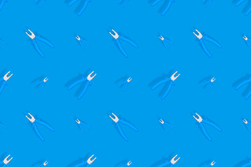 Fototapeta premium Background of metal pliers with rubber handles. Tools seamless pattern.