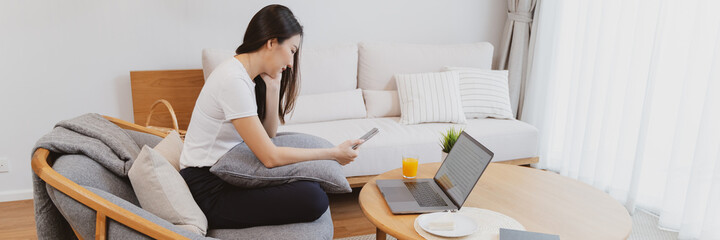 Relaxation concept, Happy asian woman working with laptop at home in the morning.