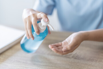 Woman using hand sanitizer alcohol gel bottle cleaning to prevent spreading of coronavirus, Covid-19..