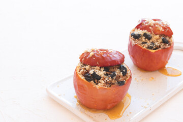 Baked apples with walnuts, raisins on a cutting board on a white background