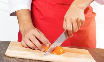 Chef hands cutting red fresh pepper