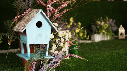 Decorative nesting boxes on bright background. Blue birdhouse on green background