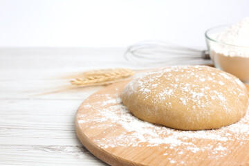 Close-up of dough on wooden board. The process of preparing and baking dough products. Copy space.