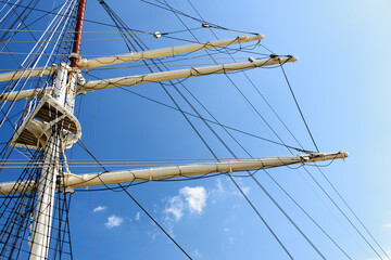 Fototapeta premium Details of the masts and rigging of the sailing ship against the blue sky in close-up